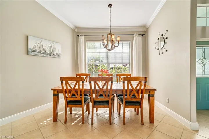 Dining space with plenty of natural light, crown molding, light tile patterned flooring, and a chandelier