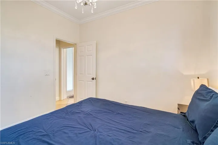 Bedroom with ornamental molding and a chandelier
