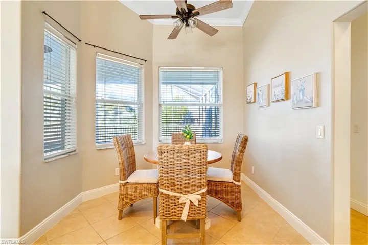 Dining space with crown molding, ceiling fan, and light tile patterned floors