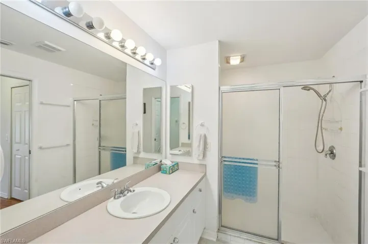 Bathroom featuring vanity, a stall shower, and visible vents