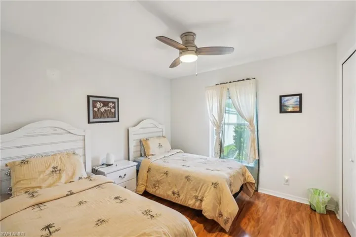 Bedroom featuring baseboards, a ceiling fan, a closet, and wood finished floors