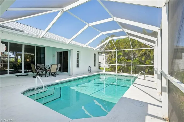 Outdoor pool featuring a patio and glass enclosure