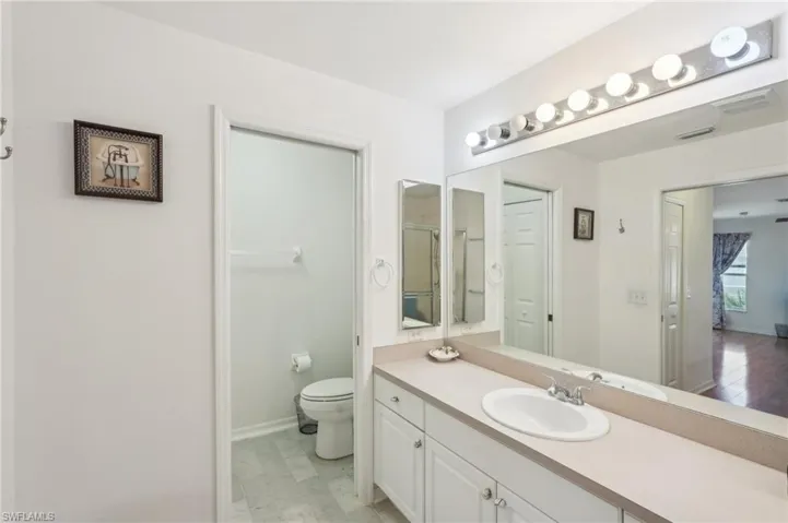 Full bath with visible vents, baseboards, toilet, and vanity