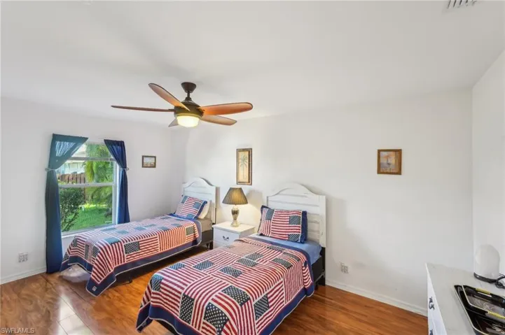 Bedroom featuring baseboards, a ceiling fan, and wood finished floors