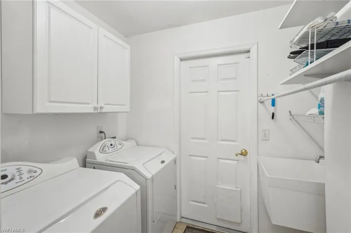 Washroom with cabinet space, independent washer and dryer, and a sink