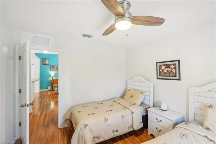 Bedroom featuring ceiling fan, visible vents, and wood finished floors