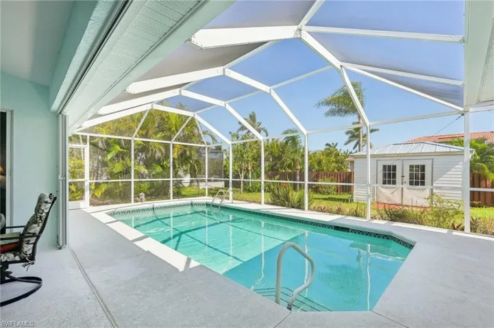 View of swimming pool with a fenced in pool, fence, an outbuilding, and a patio area