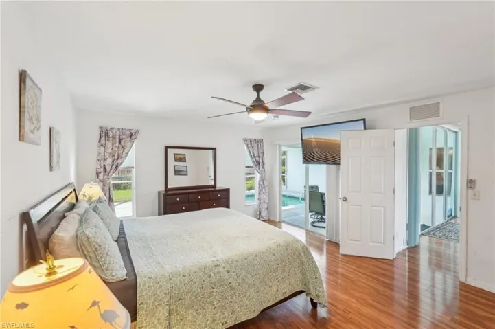 Bedroom featuring visible vents, wood finished floors, and multiple windows
