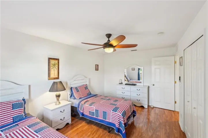 Bedroom with a ceiling fan, wood finished floors, and a closet
