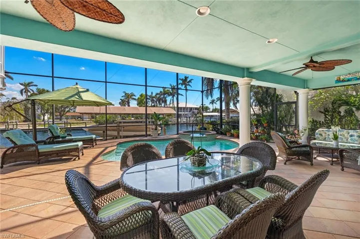 Pool with spa, outdoor dining area, 2-story screened lanai.
