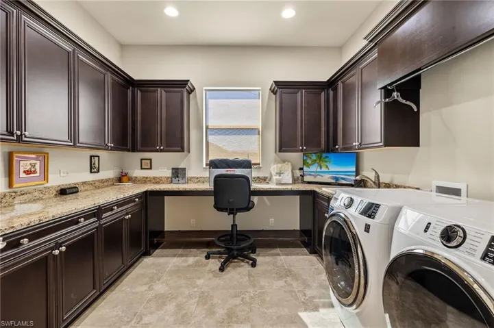 Huge laundry room with plenty of cabinetry and countertop space.