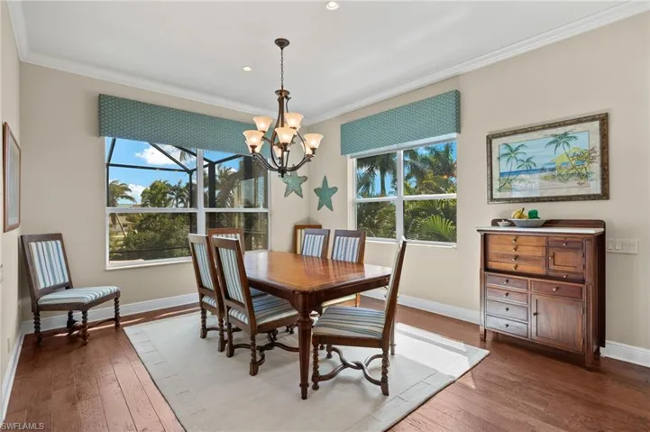 Dining area featuring baseboards, crown molding, and wood-type flooring
