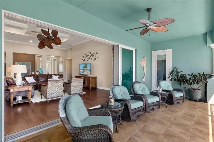 Living area with coffered ceiling, crown molding, recessed lighting, beam ceiling, and a ceiling fan