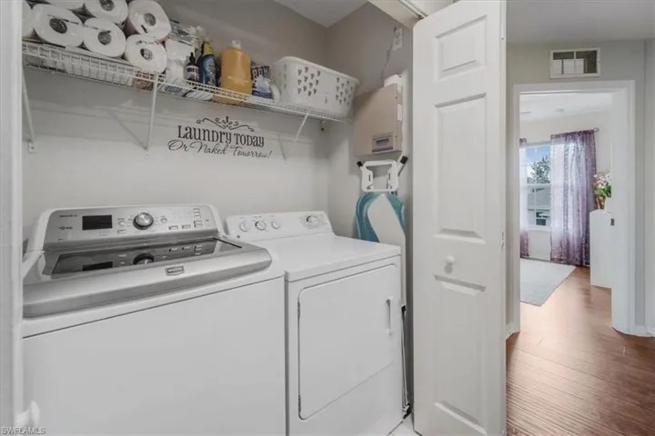 Washroom featuring wood-type flooring and washer and clothes dryer