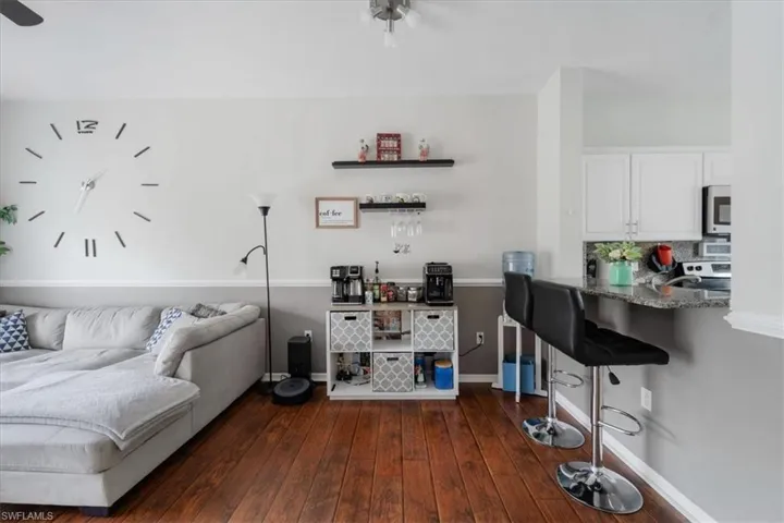 Living room featuring ceiling fan and dark hardwood / wood-style flooring