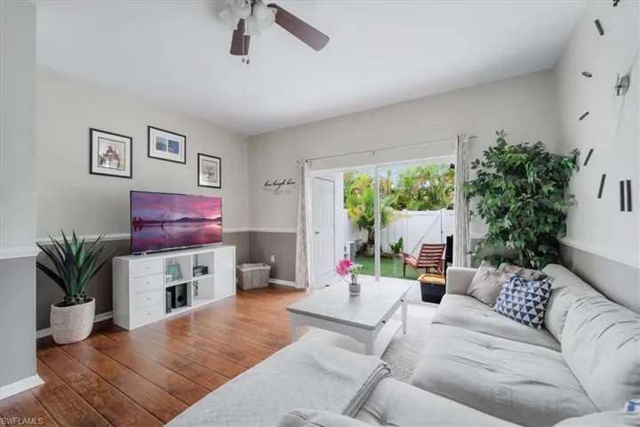 Living room with ceiling fan and hardwood / wood-style floors
