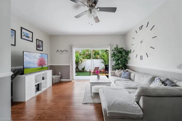 Living room with dark hardwood / wood-style floors and ceiling fan
