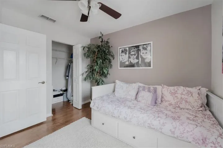 Bedroom featuring a closet, dark hardwood / wood-style flooring, and ceiling fan
