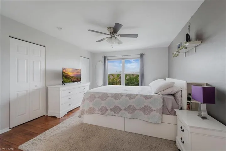 Bedroom with ceiling fan and dark hardwood / wood-style floors