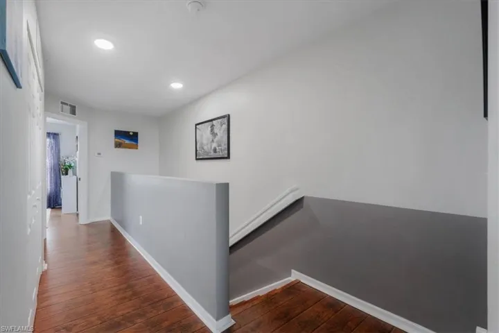 Hall with dark hardwood / wood-style flooring