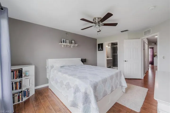 Bedroom featuring ceiling fan, hardwood / wood-style flooring, and connected bathroom