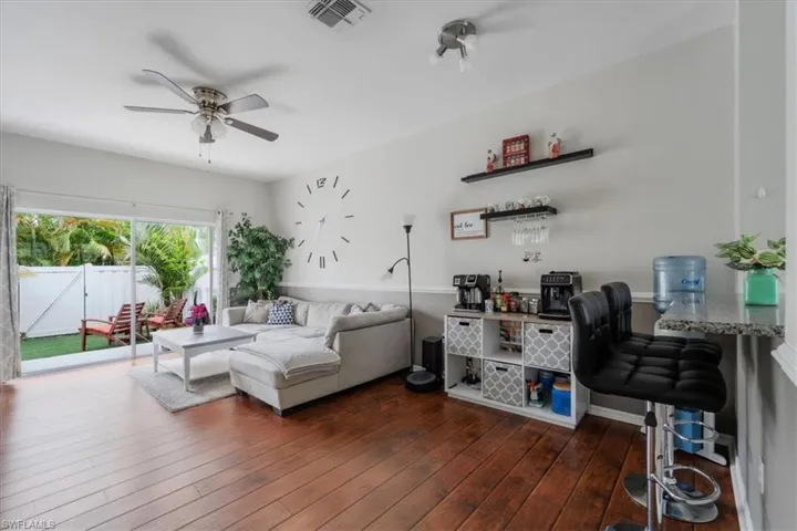 Living room with ceiling fan and dark hardwood / wood-style flooring