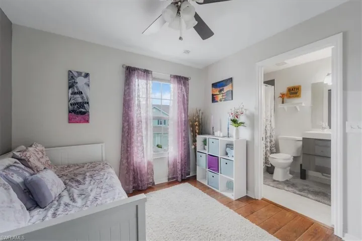 Bedroom featuring connected bathroom, ceiling fan, and hardwood / wood-style flooring