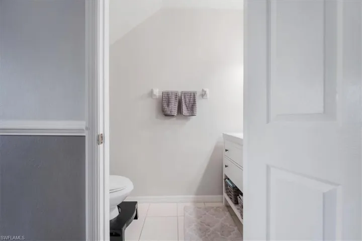 Bathroom featuring vanity, tile patterned flooring, and toilet