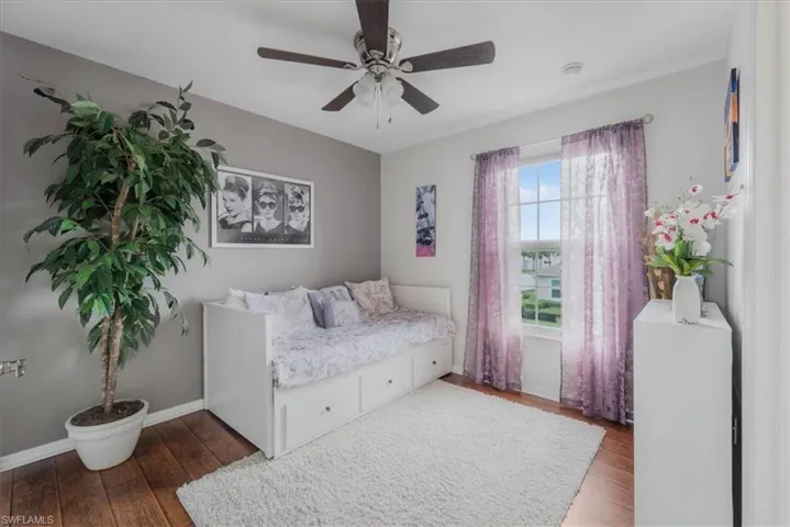 Bedroom with ceiling fan and hardwood / wood-style flooring