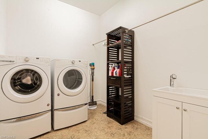Spacious laundry room with tub and hanging rack