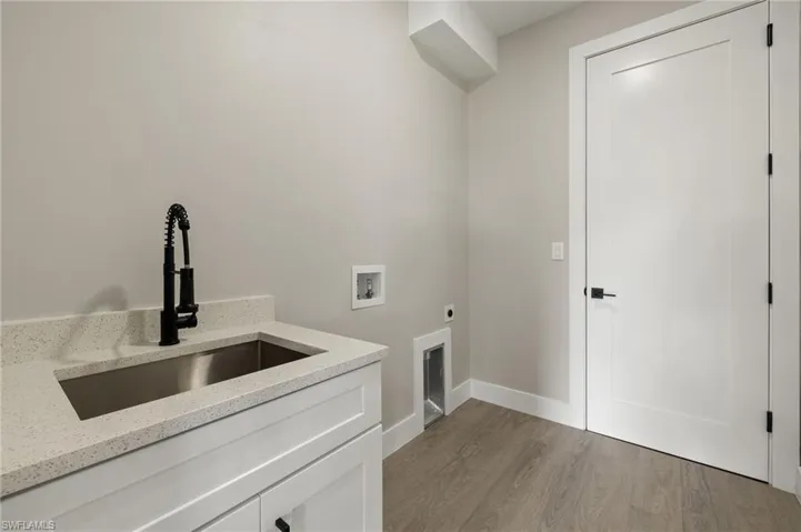 Laundry room with cabinets, hookup for an electric dryer, light hardwood / wood-style floors, sink, and hookup for a washing machine