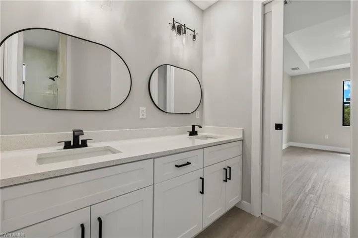 Bathroom featuring vanity, walk in shower, and hardwood / wood-style floors