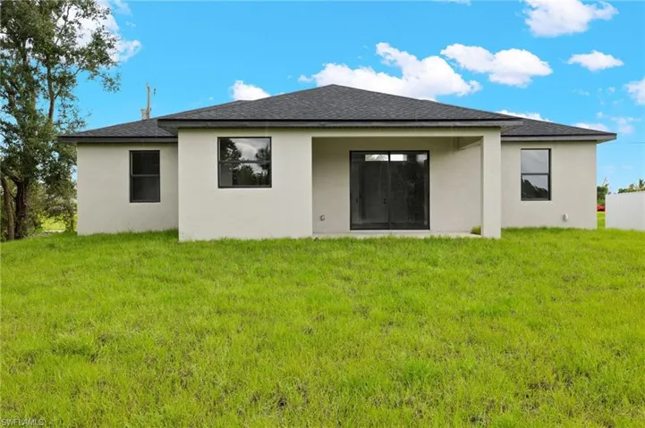 Rear view of property featuring a yard