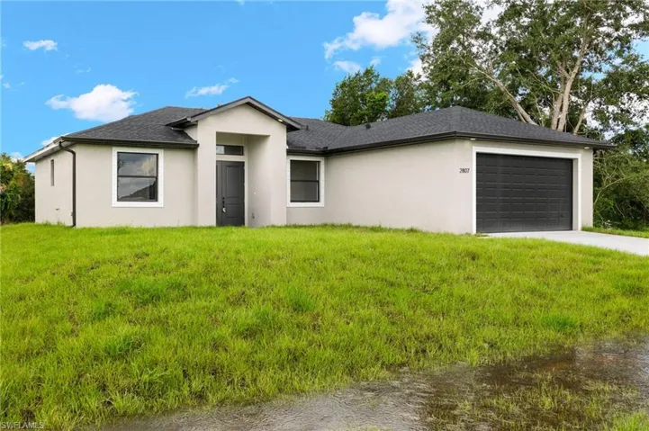 View of front of home with a front yard and a garage
