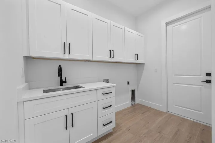 Spacious laundry room with built in cabinet storage