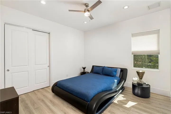 Bedroom with light wood-style floors, ceiling fan, recessed lighting, and a closet