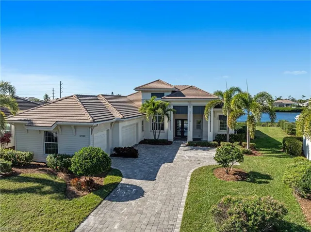View of front of house featuring a front lawn, french doors, an attached garage, decorative driveway, and a tile roof