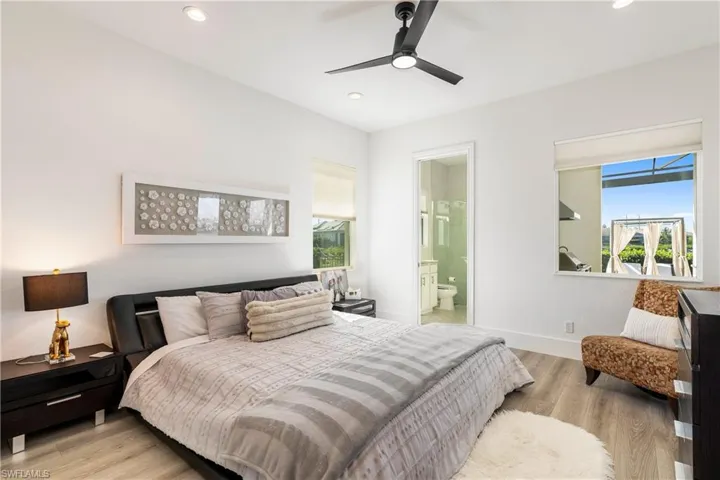Bedroom featuring light wood-style flooring, connected bathroom, a ceiling fan, and recessed lighting