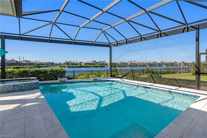 View of swimming pool featuring glass enclosure, a water view, a pool with connected hot tub, a sunroom, and a residential view