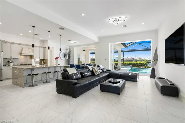 Living area featuring a sunroom, recessed lighting, and light marble finish floors