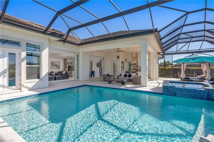 View of pool with an outdoor hangout area, a patio area, a sunroom, and a pool with connected hot tub