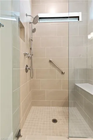 Walk in shower with tile to the ceiling, upgraded fixtures and frame-less shower door