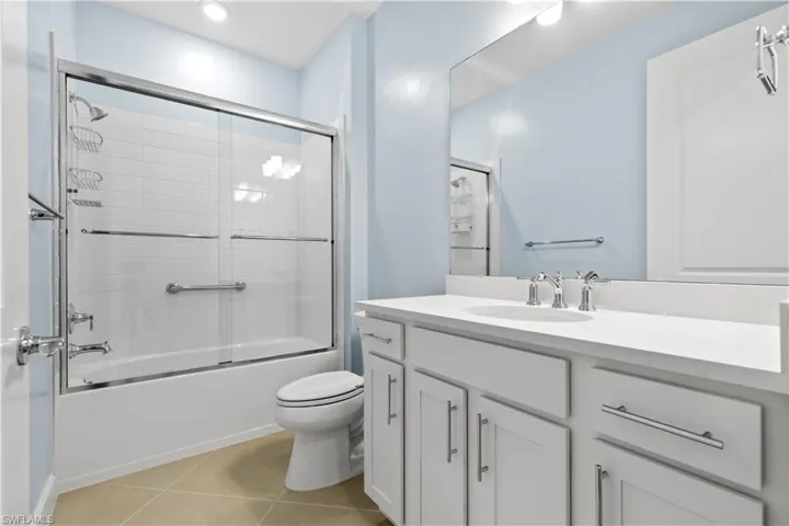 Guest Bath with quartz counter, wood cabinet, glass shower door and upgraded toilet