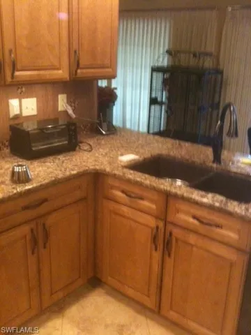 Kitchen with brown cabinets, a sink, and light tile patterned flooring