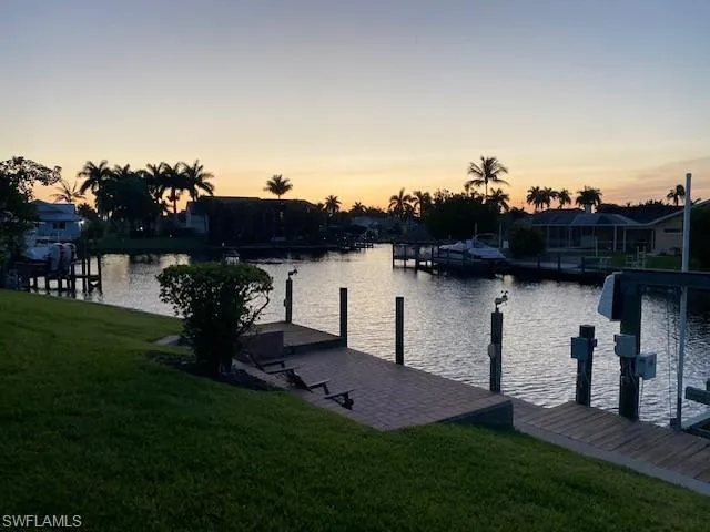 Dock area with a water view and a yard