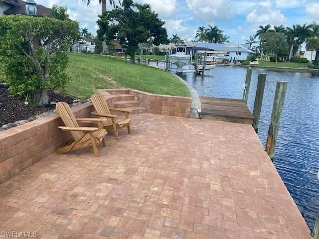 Dock area with a water view and a yard