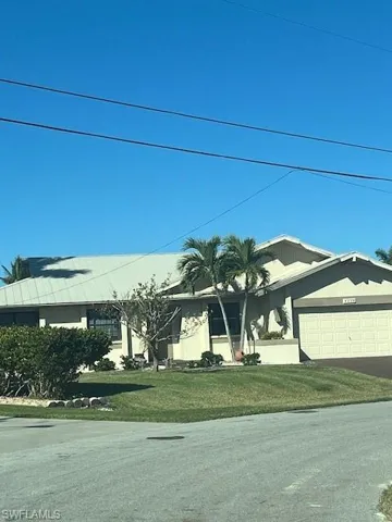 View of front of home with a garage and a front lawn