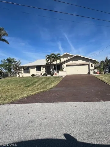 Single story home featuring a garage and a front yard