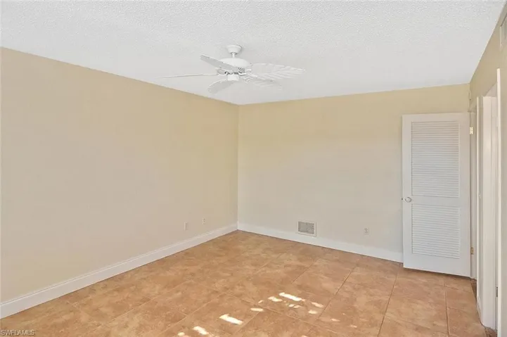 Unfurnished room featuring a textured ceiling and a ceiling fan