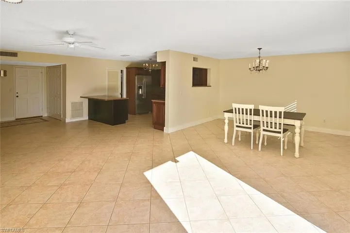 Dining area featuring a chandelier, a ceiling fan, and light tile patterned floors